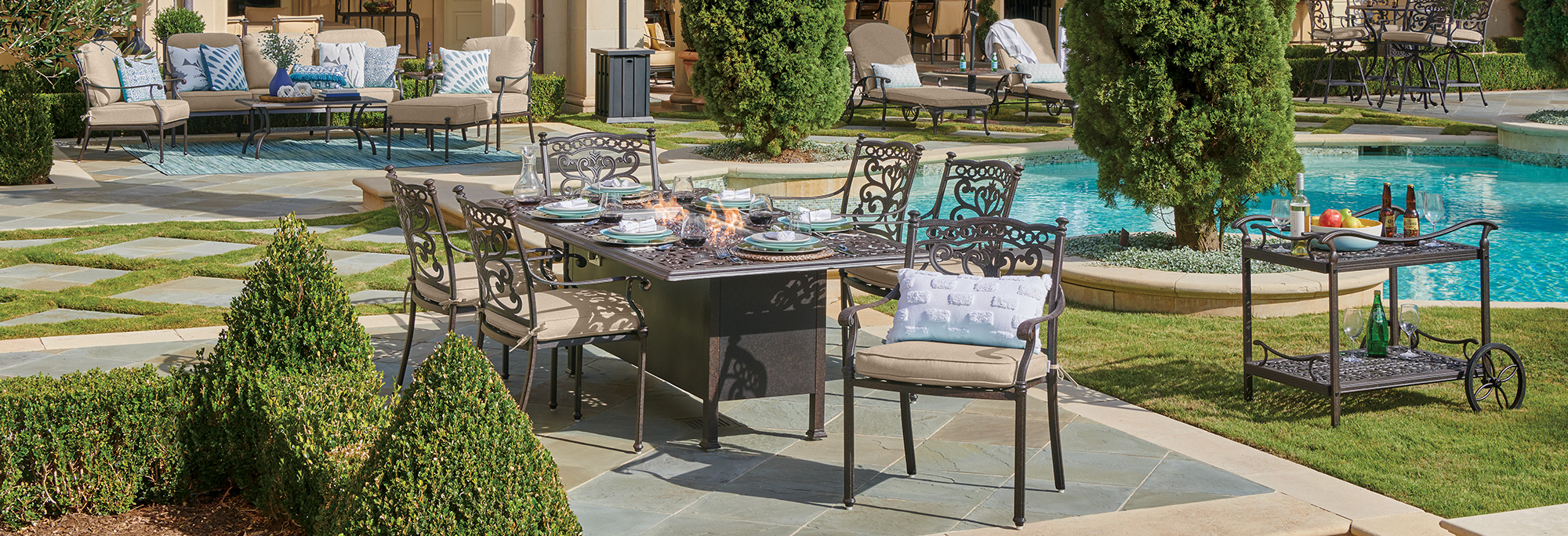 Outdoor dining area by a pool with tables and chairs.