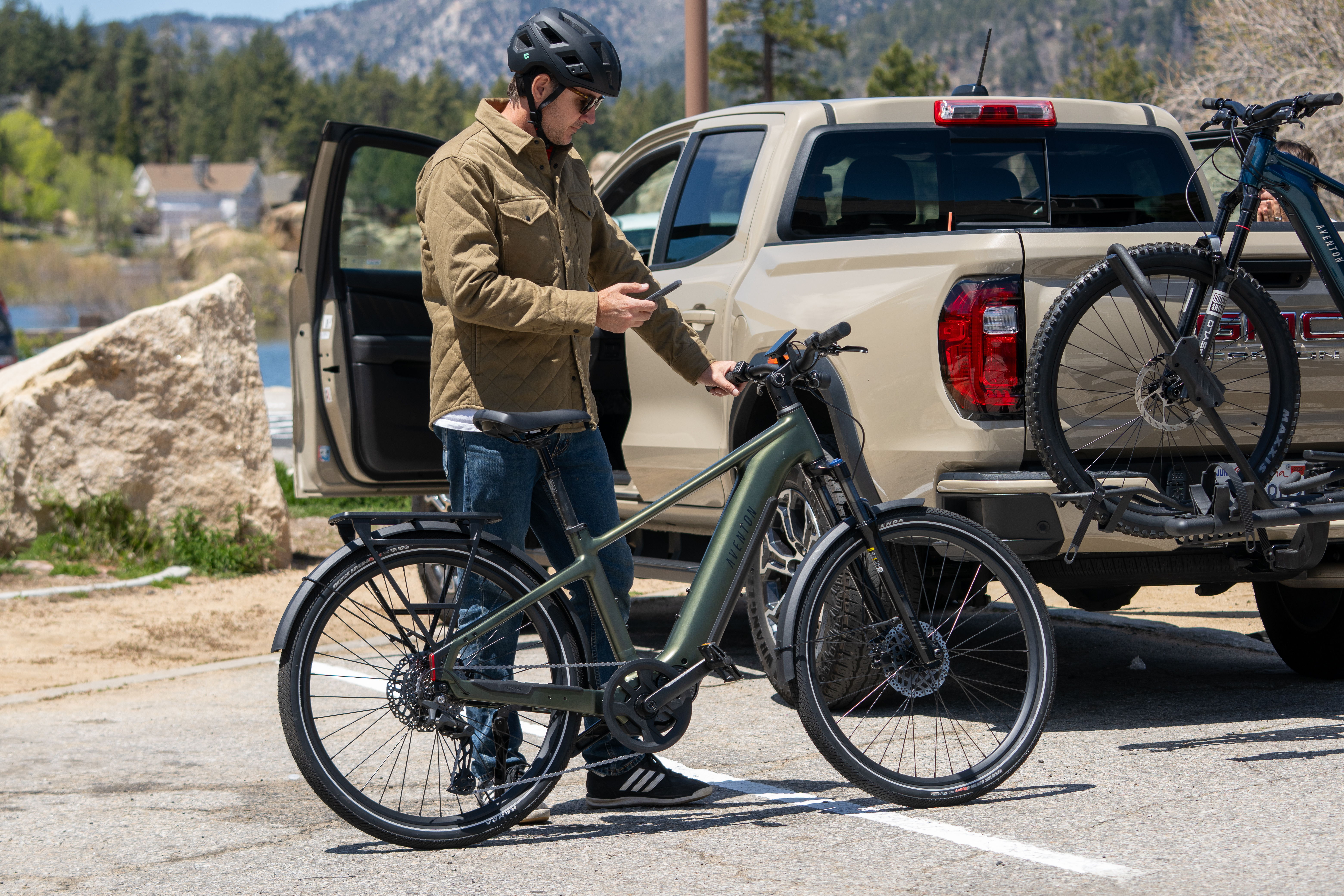 Person standing by a bike next to a truck in a scenic area.