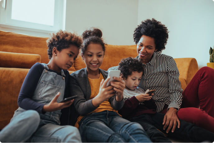 Mother with 3 children looking at a Gen Mobile smartphone sitting on the couch