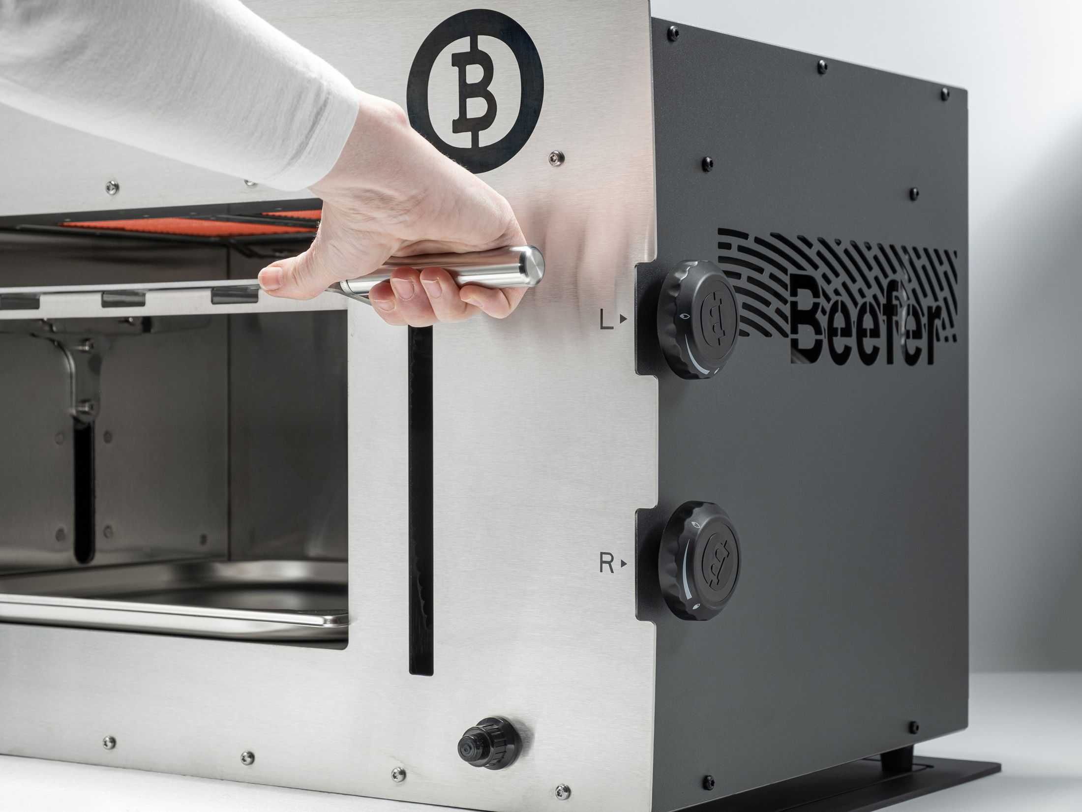 A person operating a Bitcoin-themed cooking appliance.