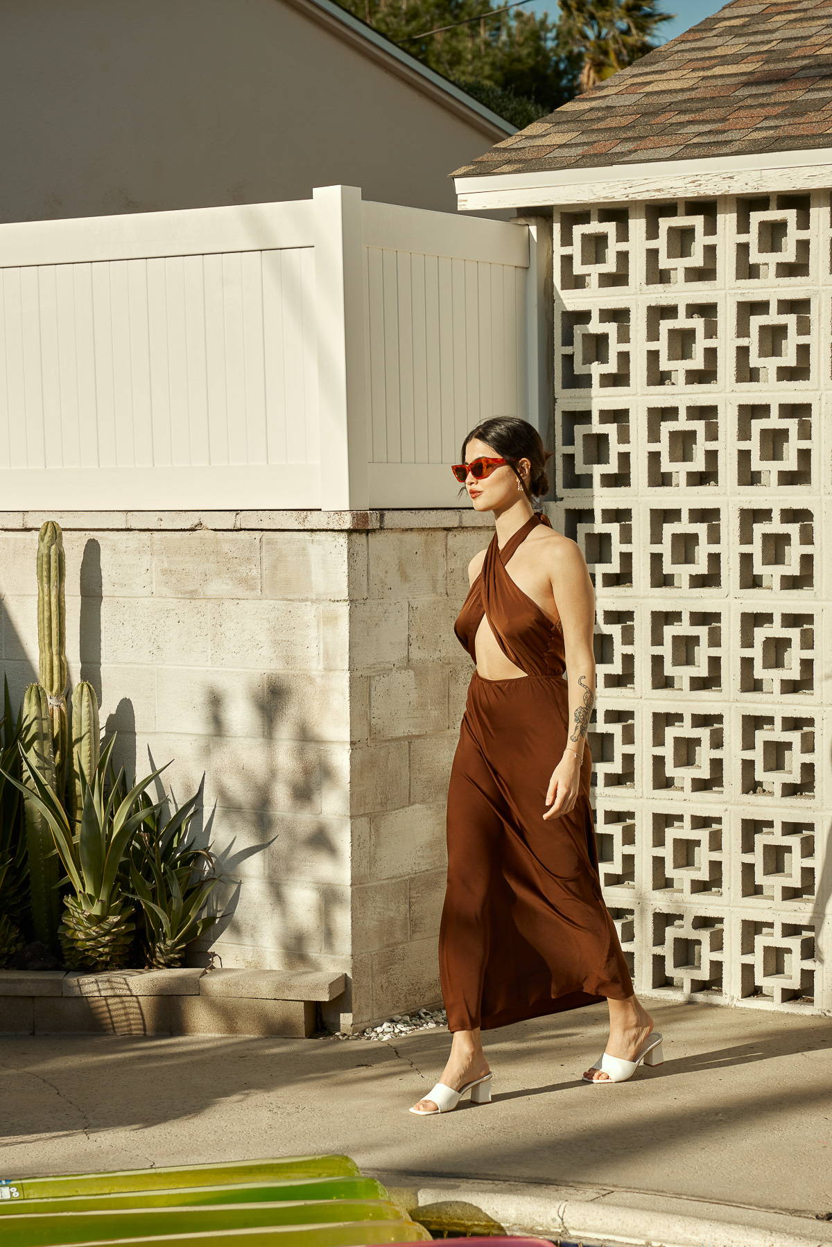 Trixxi Spring summer girl in rust color shiny cut out halter dress by the pool.