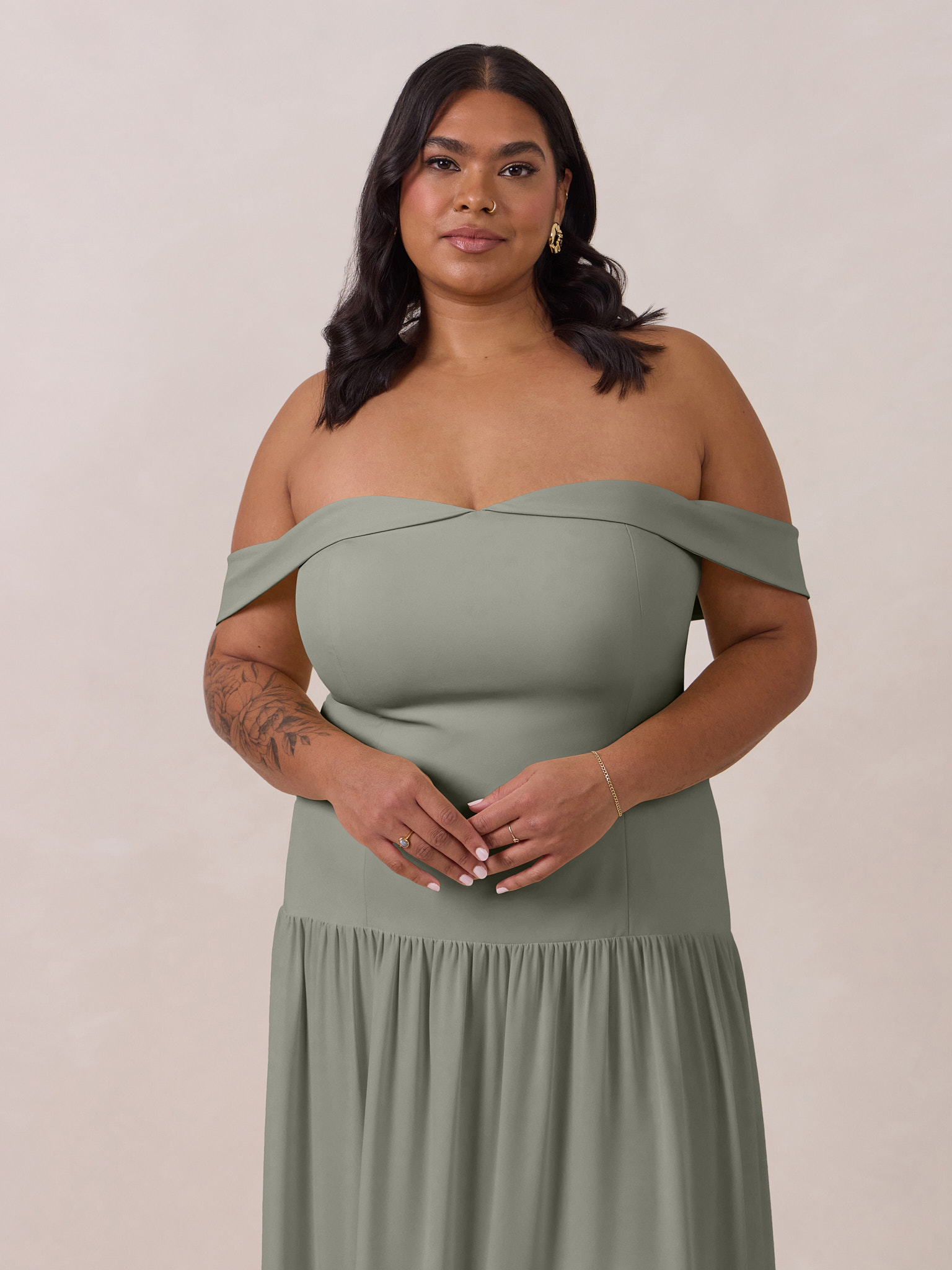 Woman wearing a long, off-the-shoulder, green dress.