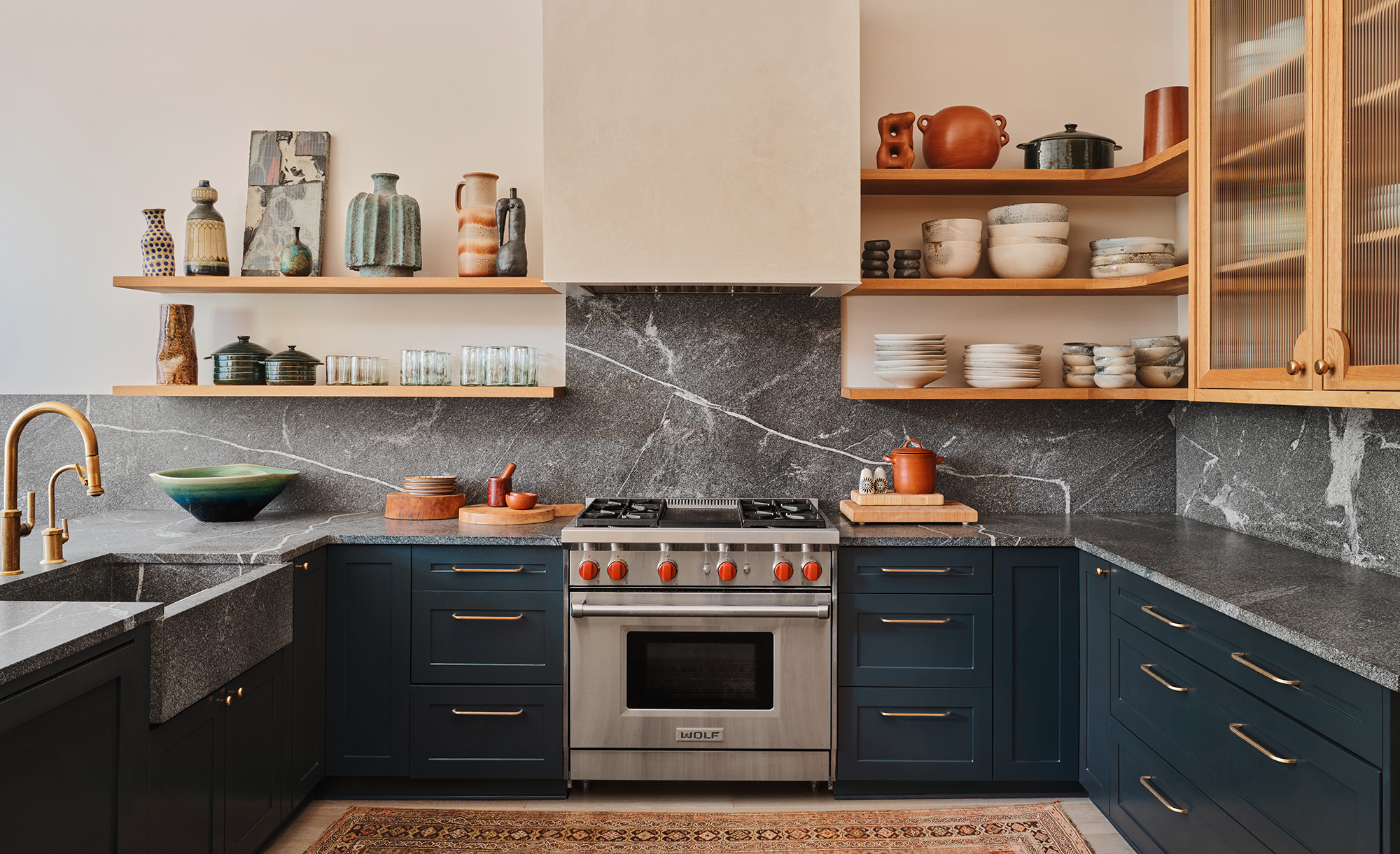 Navy and oak kitchen design by Christina Simons, finished with brass kitchen handles and open shelves