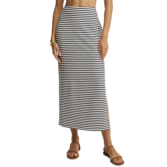 Woman wearing a striped maxi skirt and sandals.