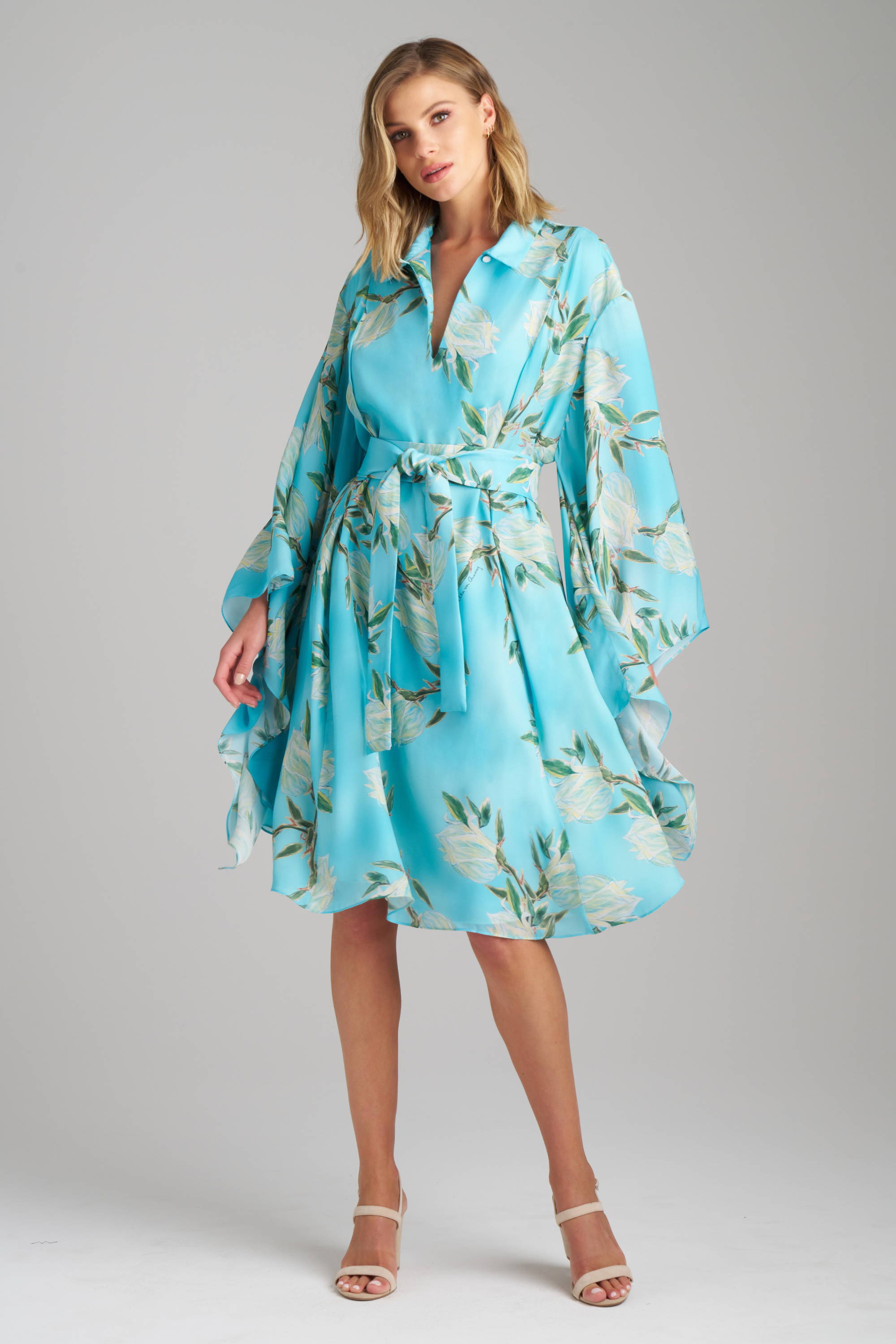Woman wearing blue floral printed silk short dress with self tie belt and kimono sleeves for women's black tie clothing for destination weddings by Ala von Auersperg