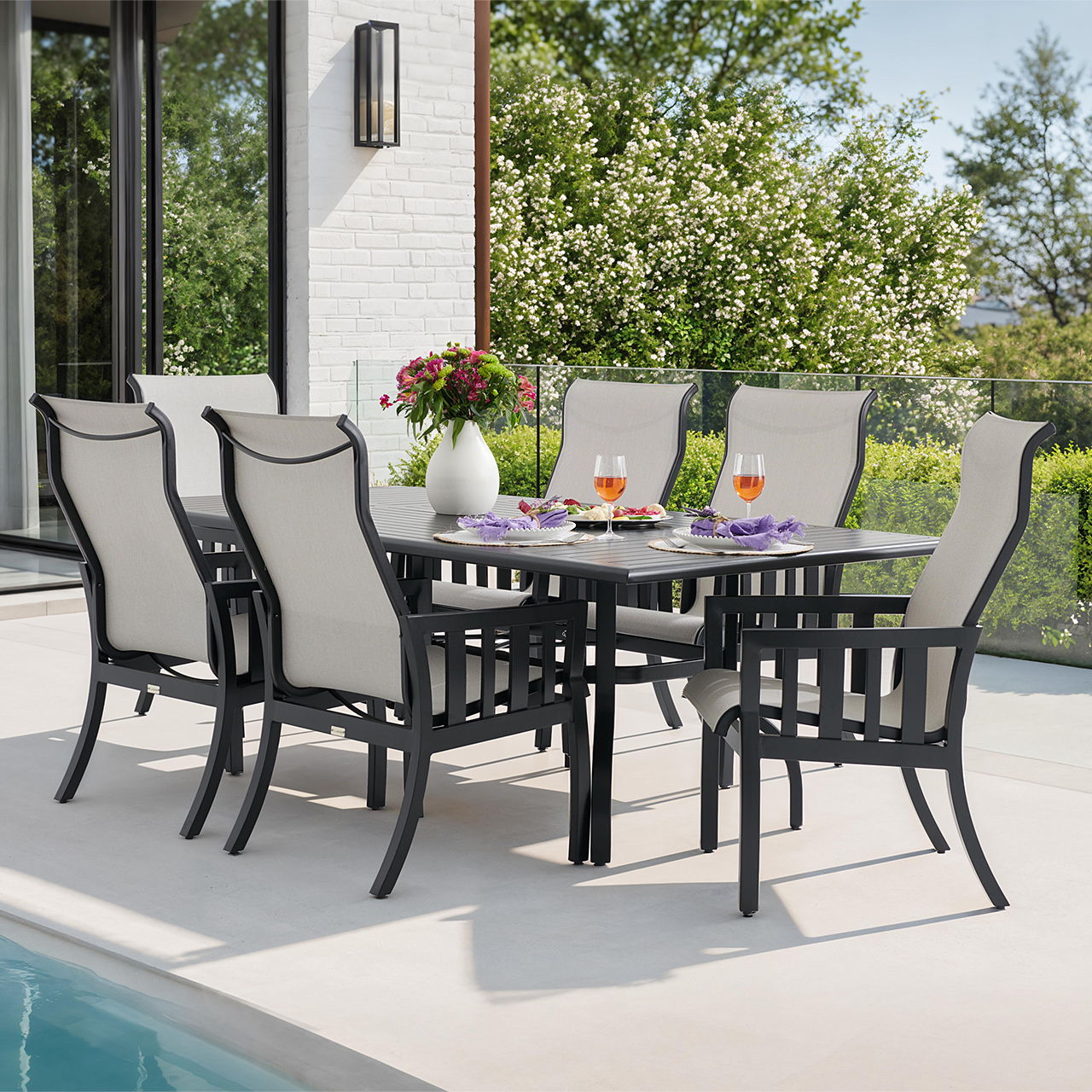 Outdoor dining set with six chairs and a table, surrounded by greenery.