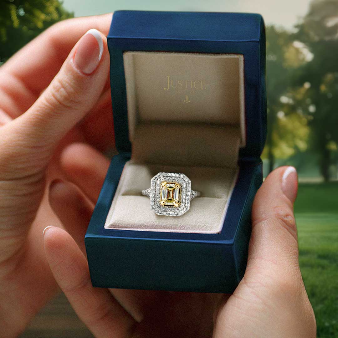 Hands holding a ring box with a custom ring from Justice Jewelers