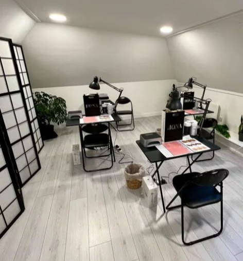 A modern workspace with desks, chairs, and lamps in a well-lit room.