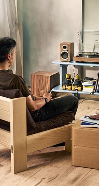 A person listening to music on a hi-fi separates system.