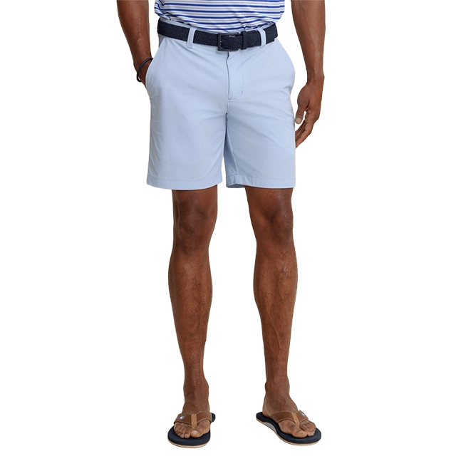 Man wearing light blue shorts and a striped shirt, standing casually.