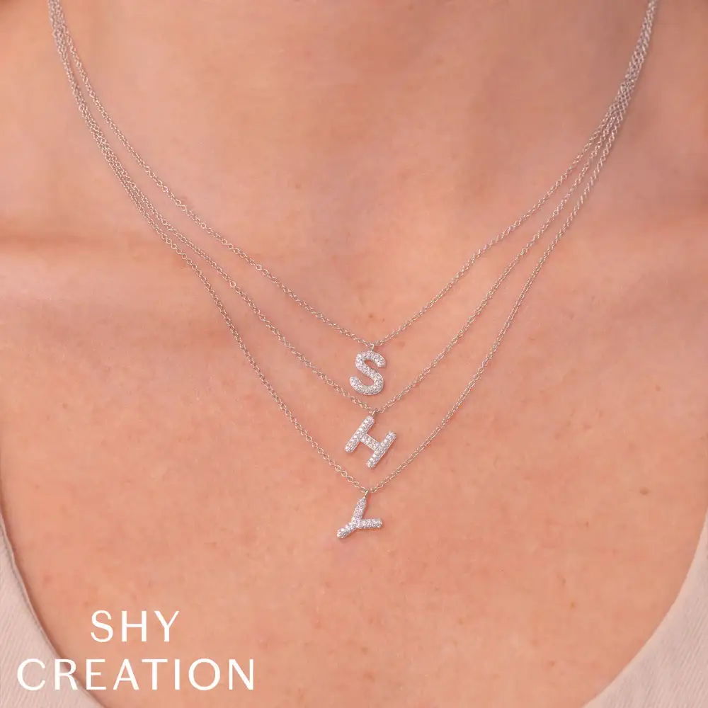 Initial necklaces around woman's neck