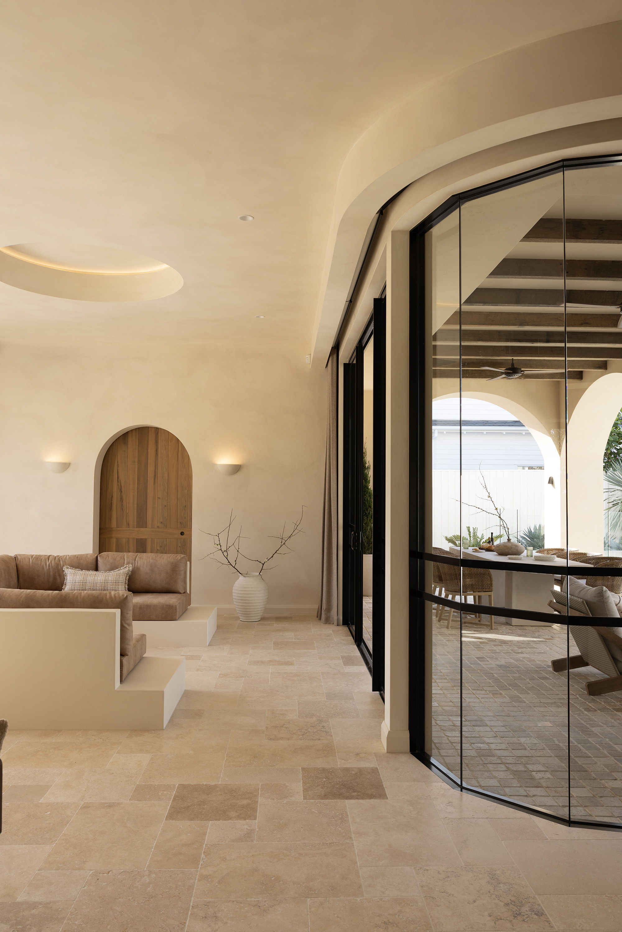 Modern interior with curved glass wall and minimalist decor.