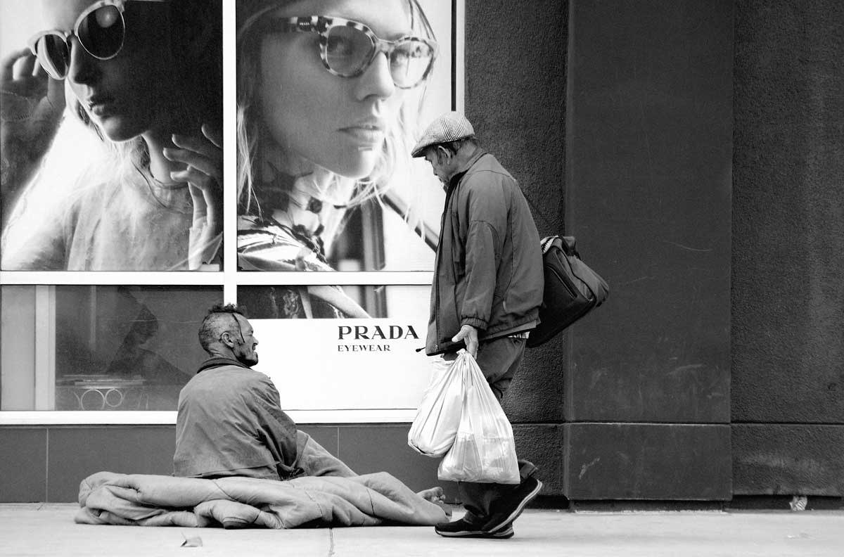A homeless person outside of Prada store