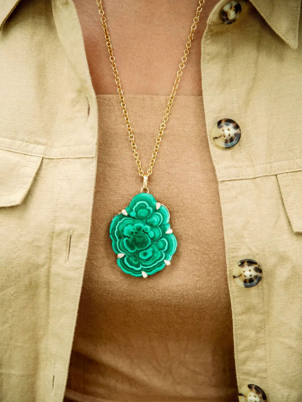 green pendant necklace around woman's neck