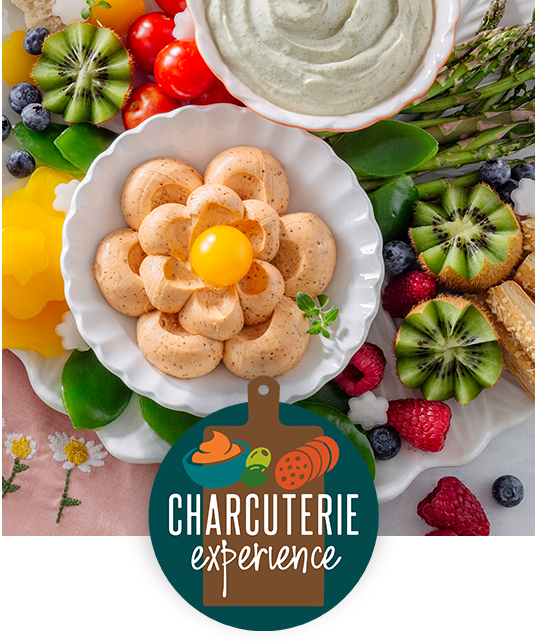 Charcuterie board with dip and fruit promoting a charcuterie experience