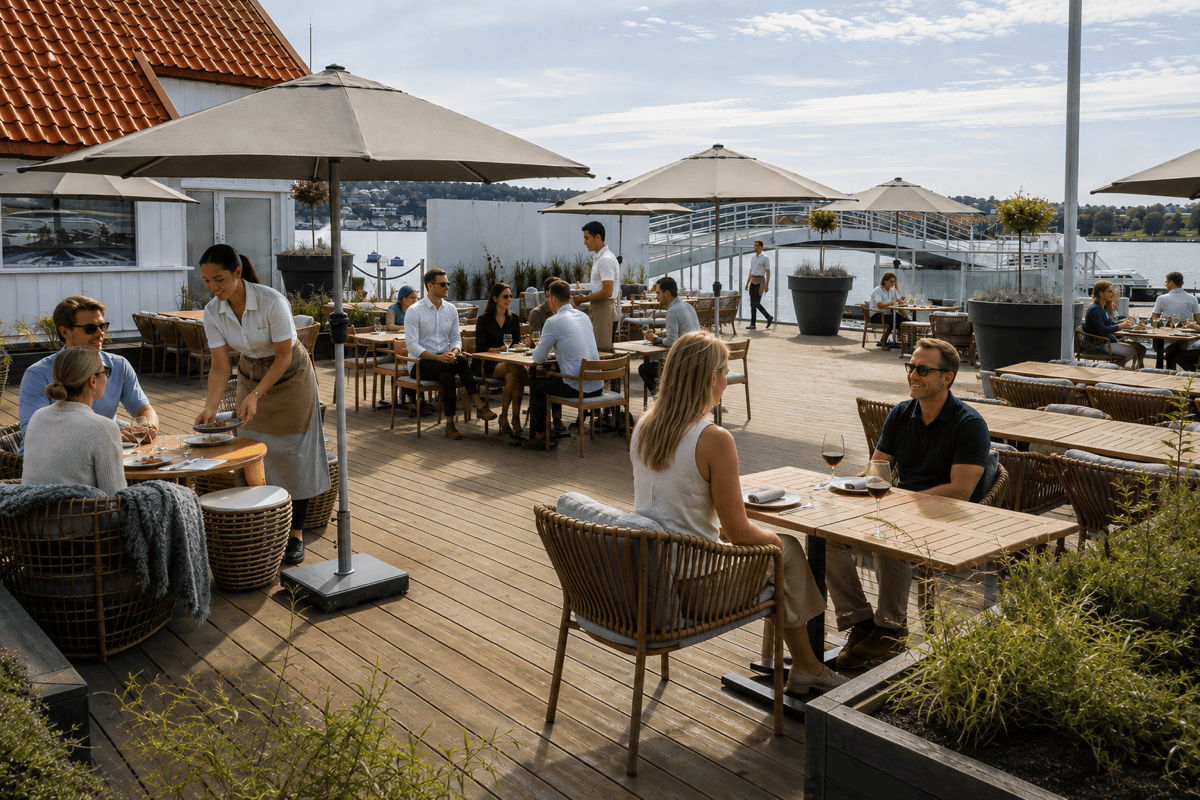 Busy waterfront restaurant patio with commercial outdoor furniture, servers, diners and flexible table arrangements