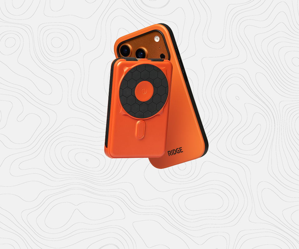 An orange smartphone with a circular attachment on a light background.