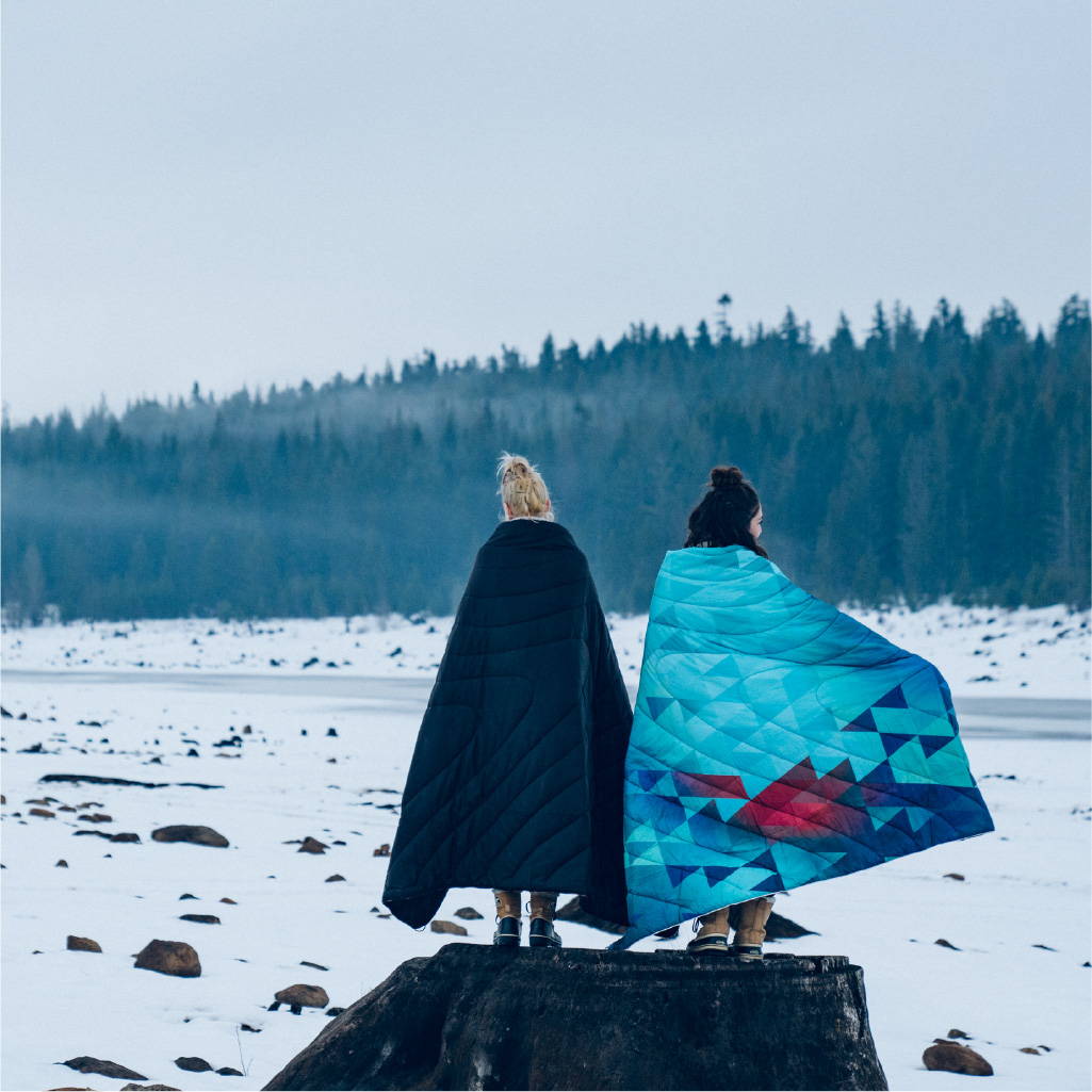 Two women standing on a frozen lake with Rumpl blankets