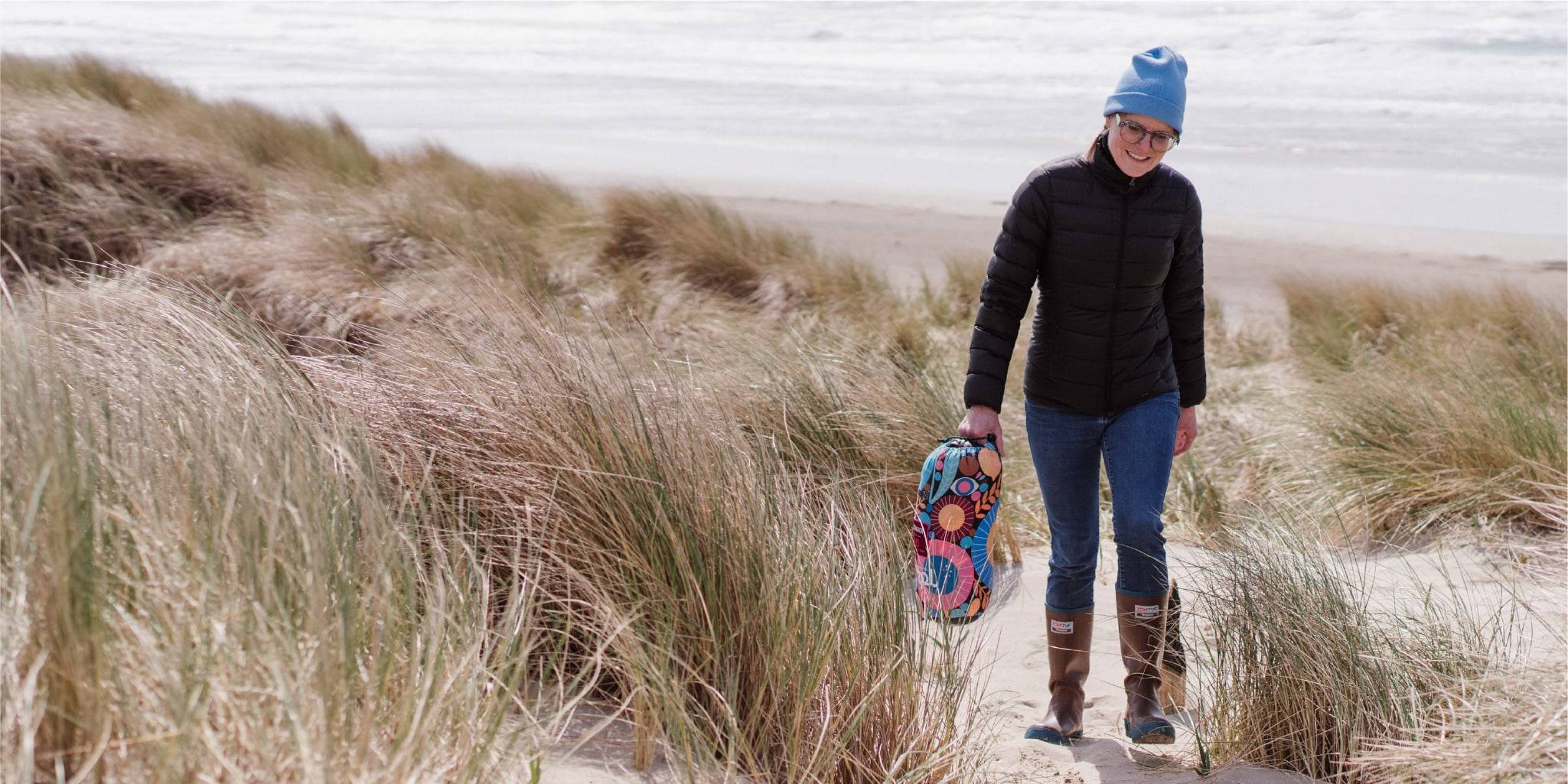 Lisa Congdon walking on beach with blanket in stuff sack