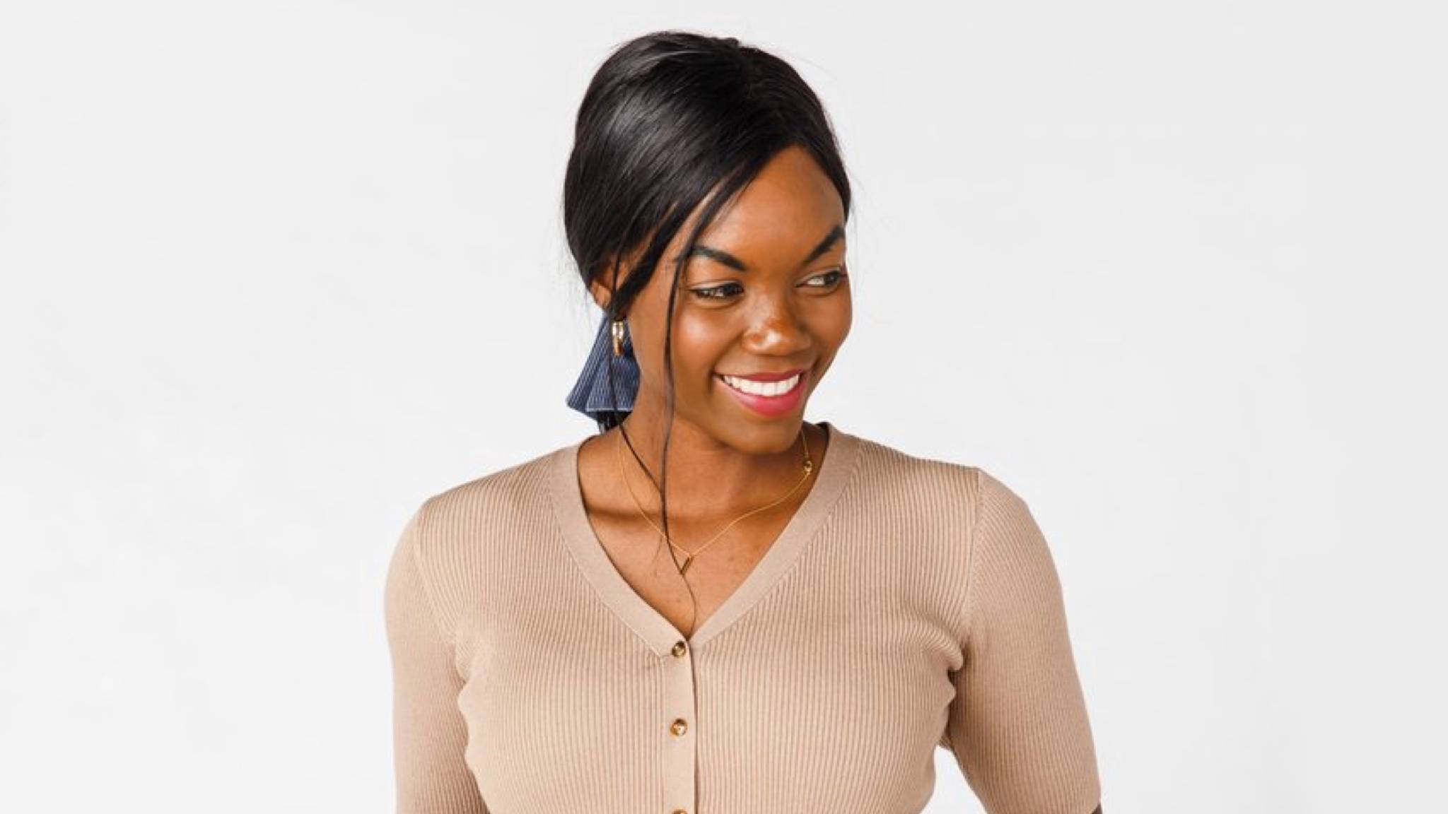 A beautiful young woman in a button-up mocha light sweater. 