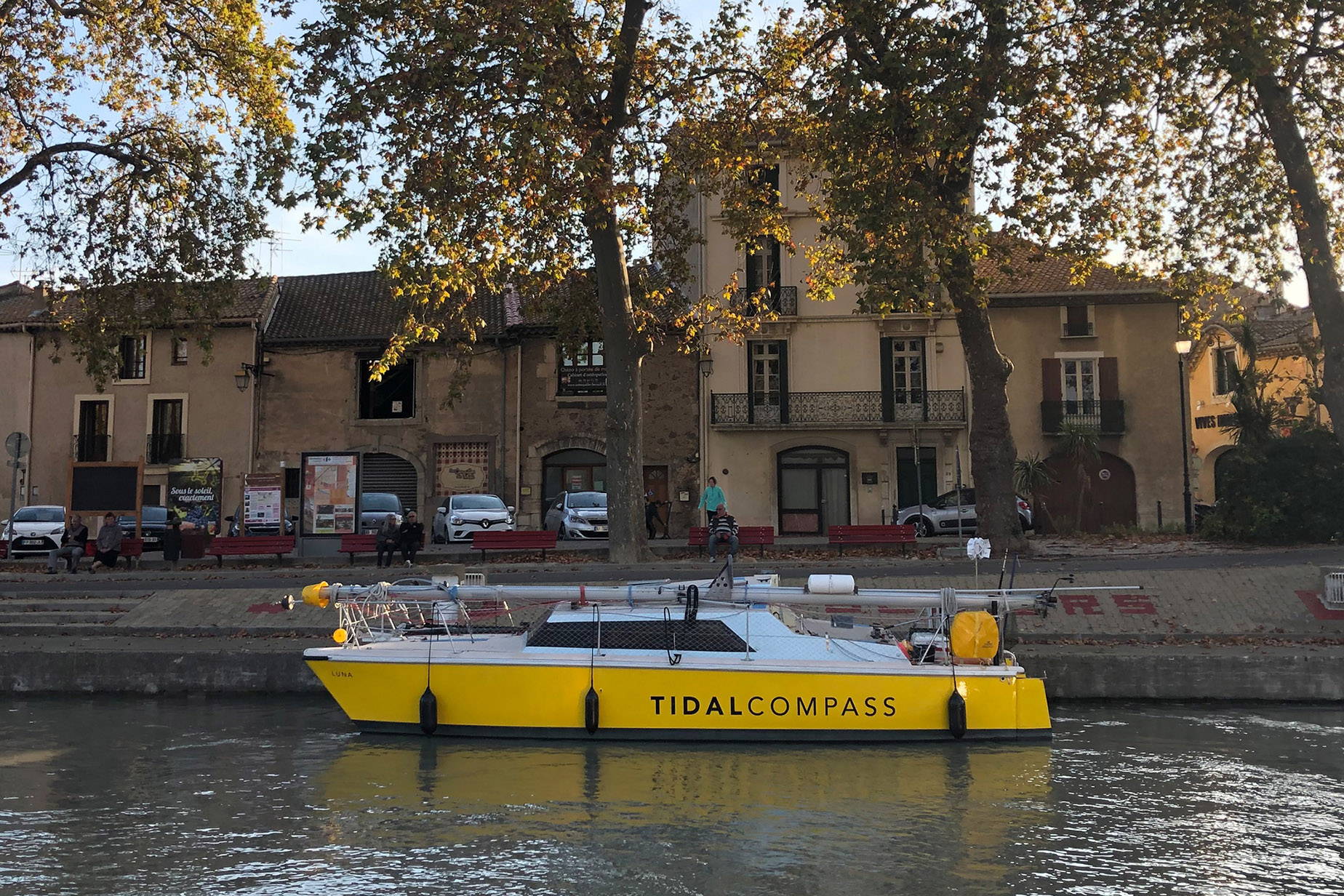 The yellow Tide School Catamaran moors up on a French canalside