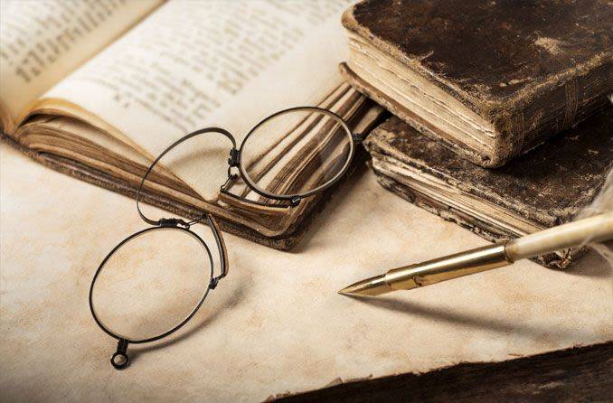 Old reading glasses from the 18th century resting on old books 