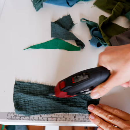 hand cutting fabric into scraps with the Madam Sew electric fabric scissors