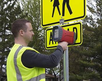 Traffic manager testing reflectivity of road sign