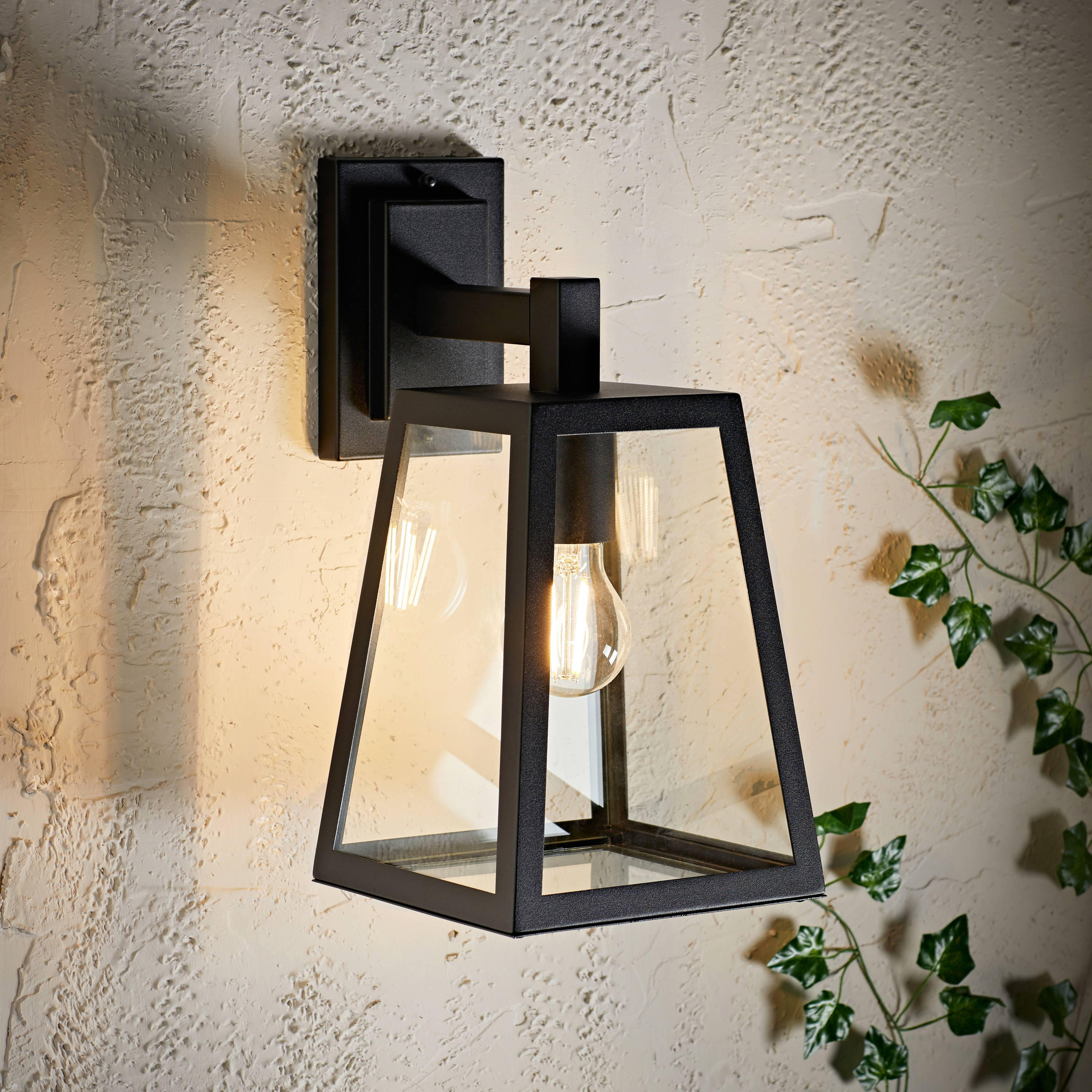 A black outdoor wall light on a textured wall