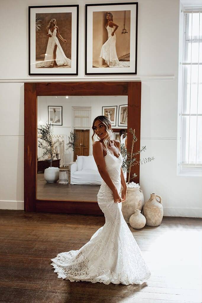 Bride wearing the Grace Loves Lace Hart gown with large timber mirror and bridal photo frames