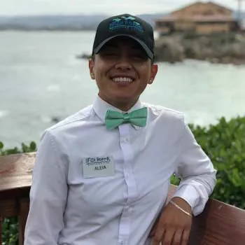 A waiter wearing a seafoam bow tie.