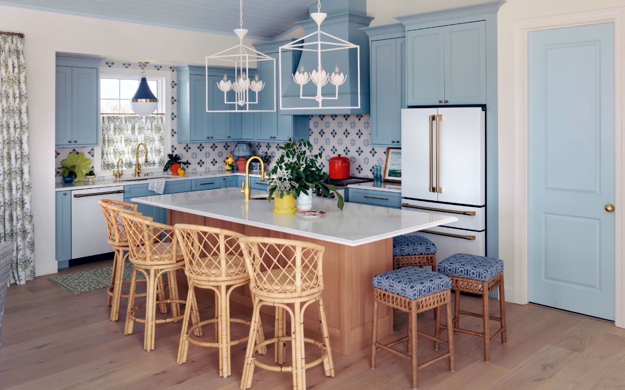 Kitchen by designer Isabel Ladd with blue cabinets, island seating, and decorative tiles.