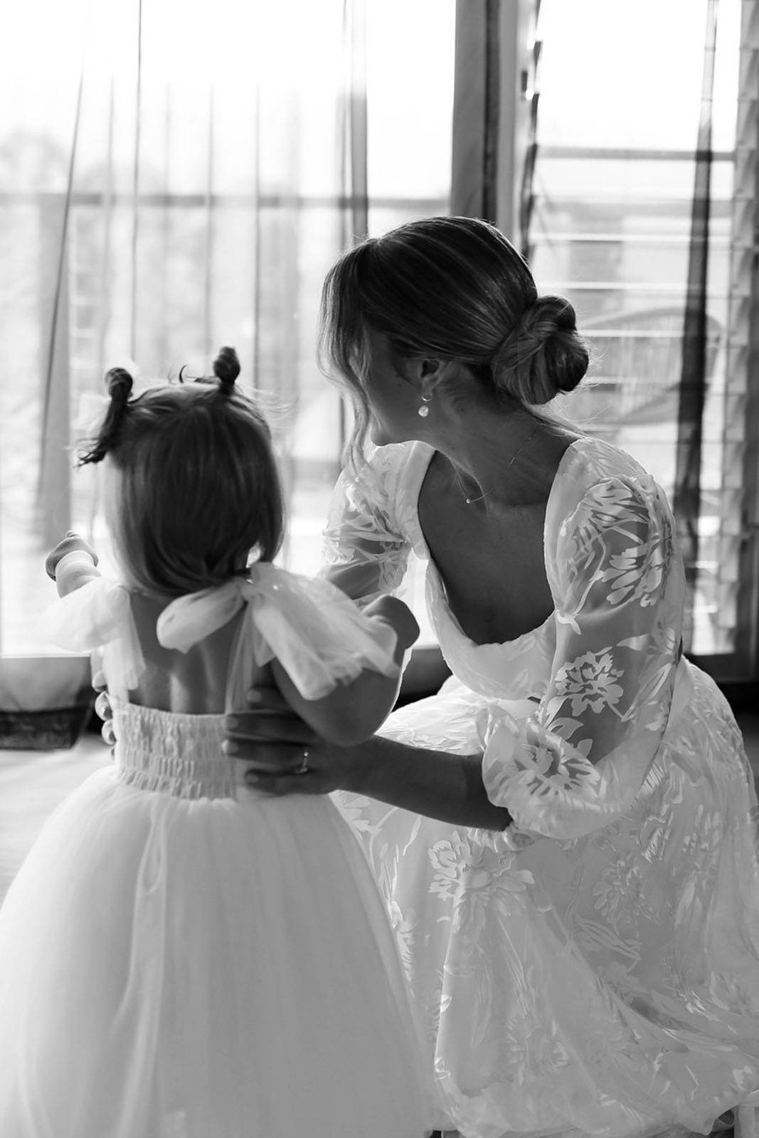 Bride and mini flower girl, sharing a cute moment