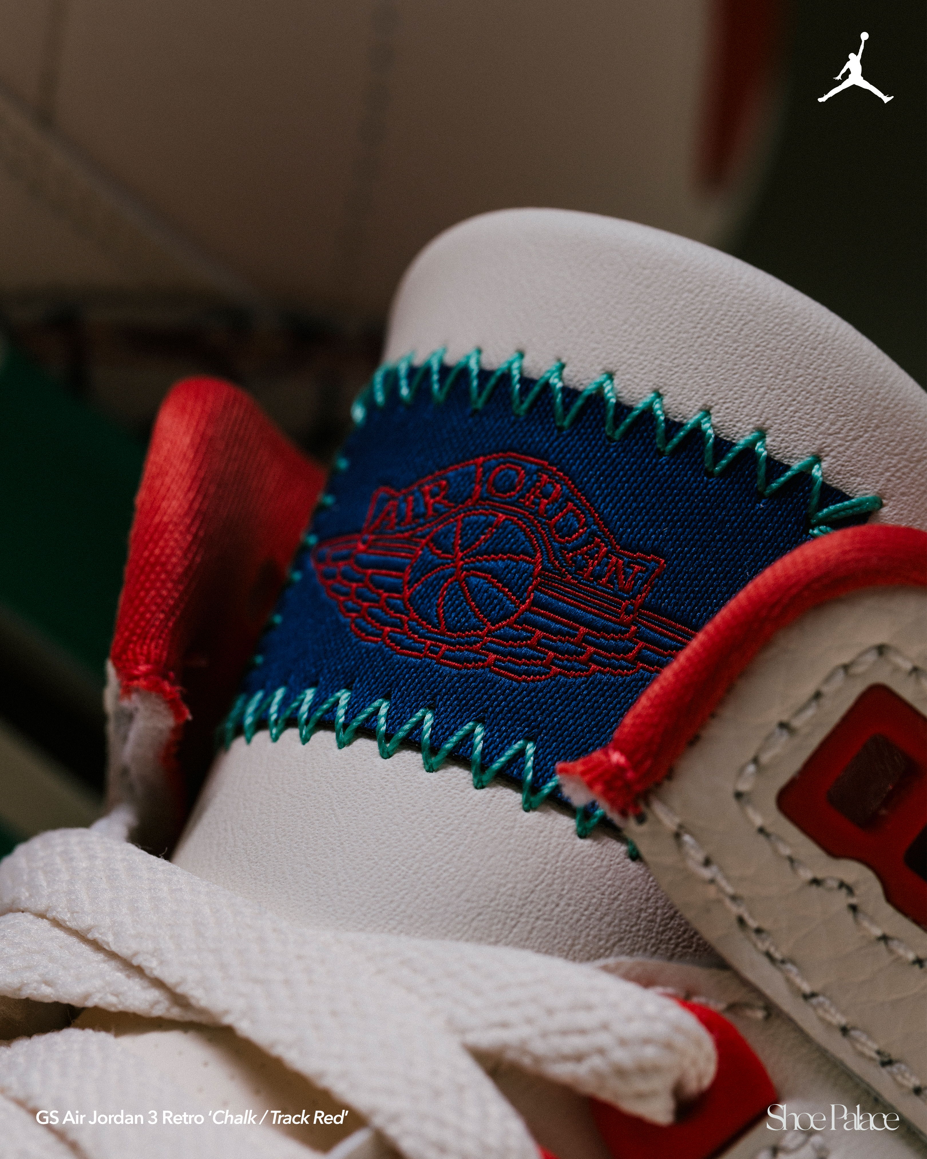 Close-up of a sneaker with a logo and colorful stitching.