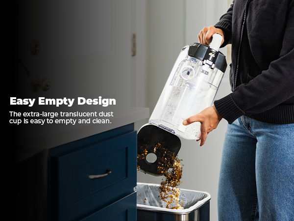 Person pouring contents from a vacuum into a trash can.