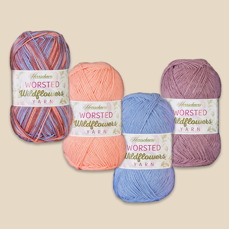 Four skeins of Herrschners Worsted Wildflowers yarn in various colors and patterns.