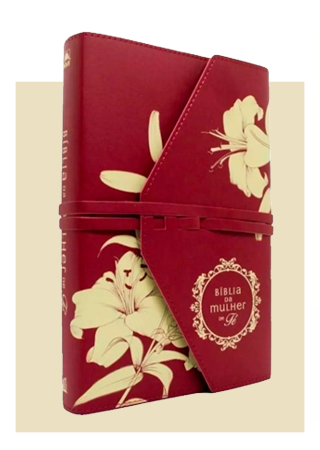 Red floral-covered notebook with an elastic closure and decorative label.