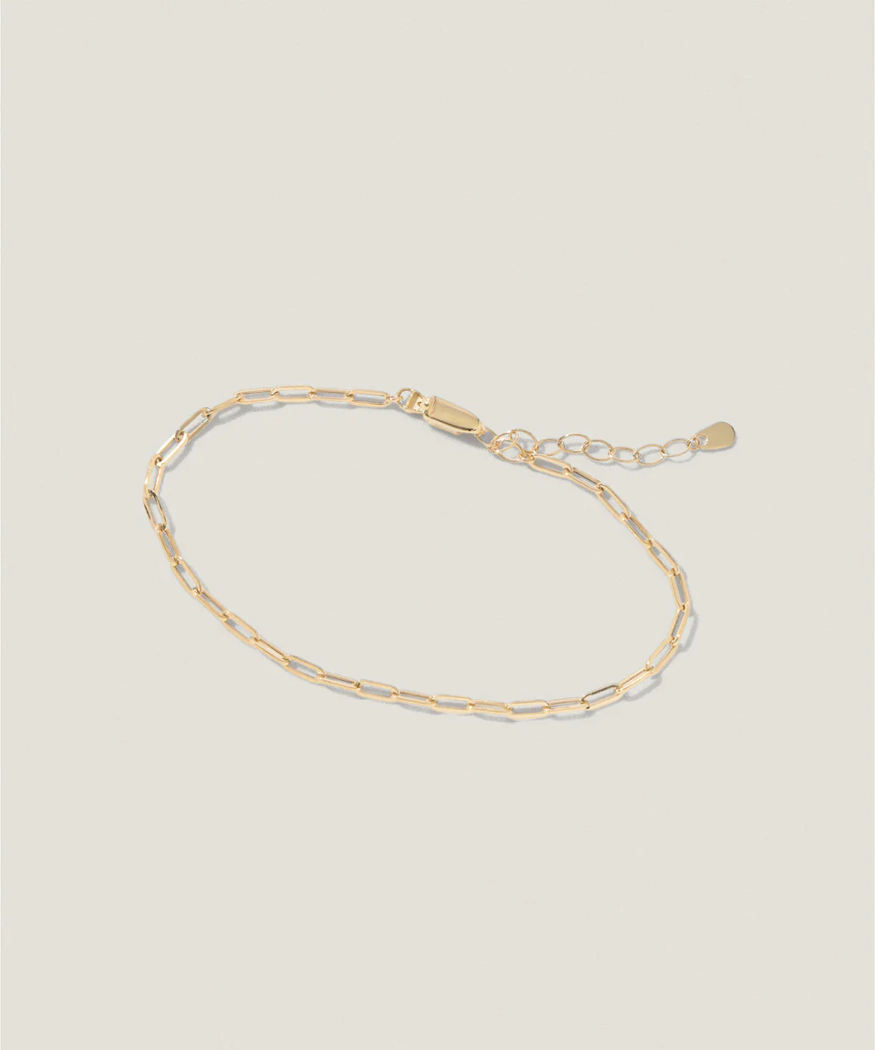 Gold chain bracelet on a light background.