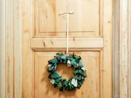 a finished diy green fabric wreath on a door