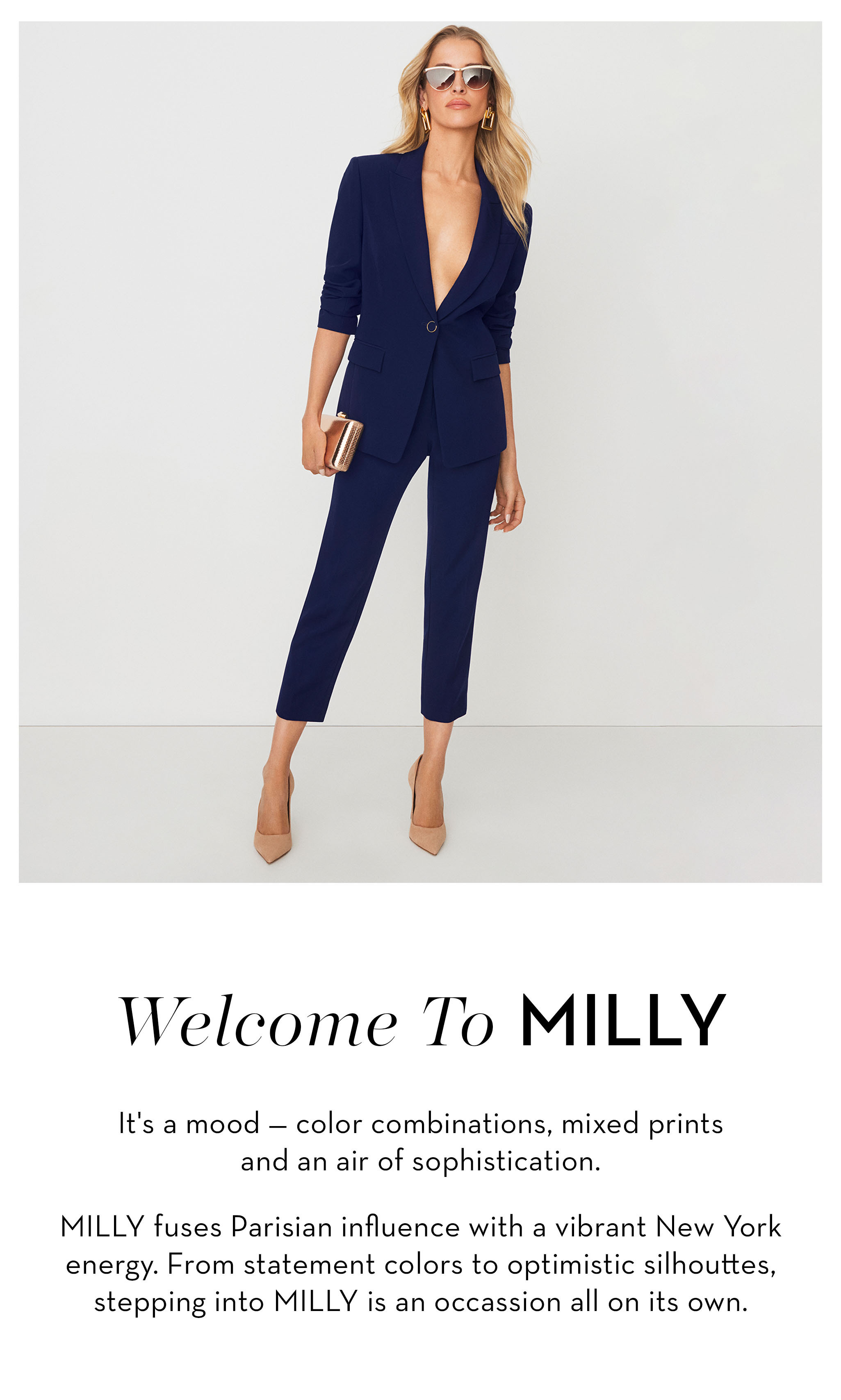 Woman in a stylish navy suit with heels, promoting fashion brand MILLY.