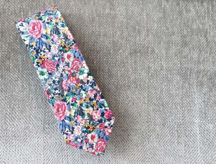 Dusty blue and pink floral tie on a gray background