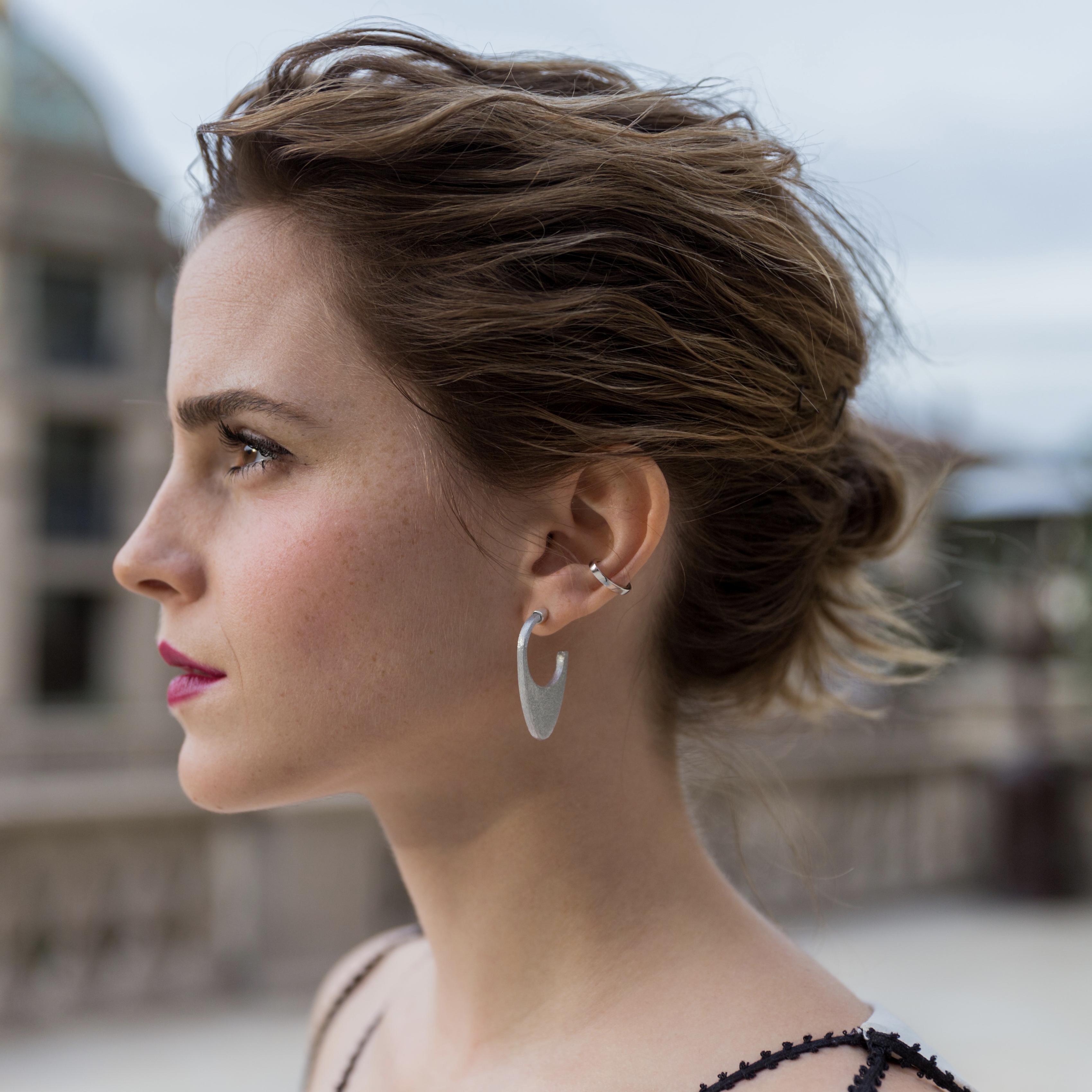 Earrings displayed alongside a quote attributed to Emma Watson.