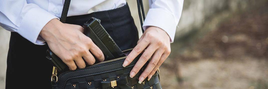 Female pulling concealed carry handgun out of purse