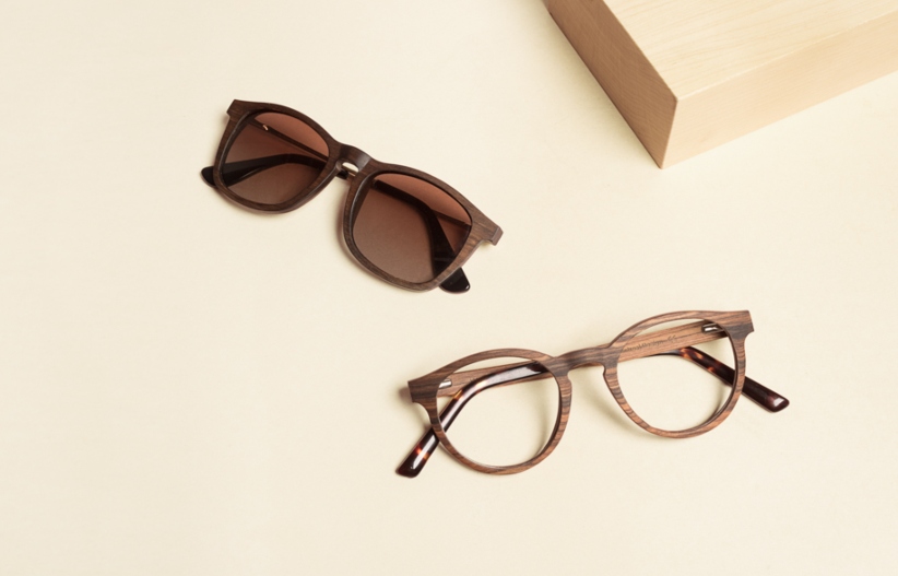 flat lay image of Kraywoods prescription sunglasses and light-adaptive glasses on neutral background