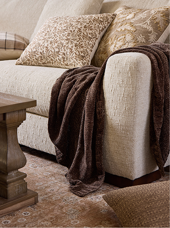 Close-up of light upholstery fabric with cozy throw blanket highlighting texture and durability.