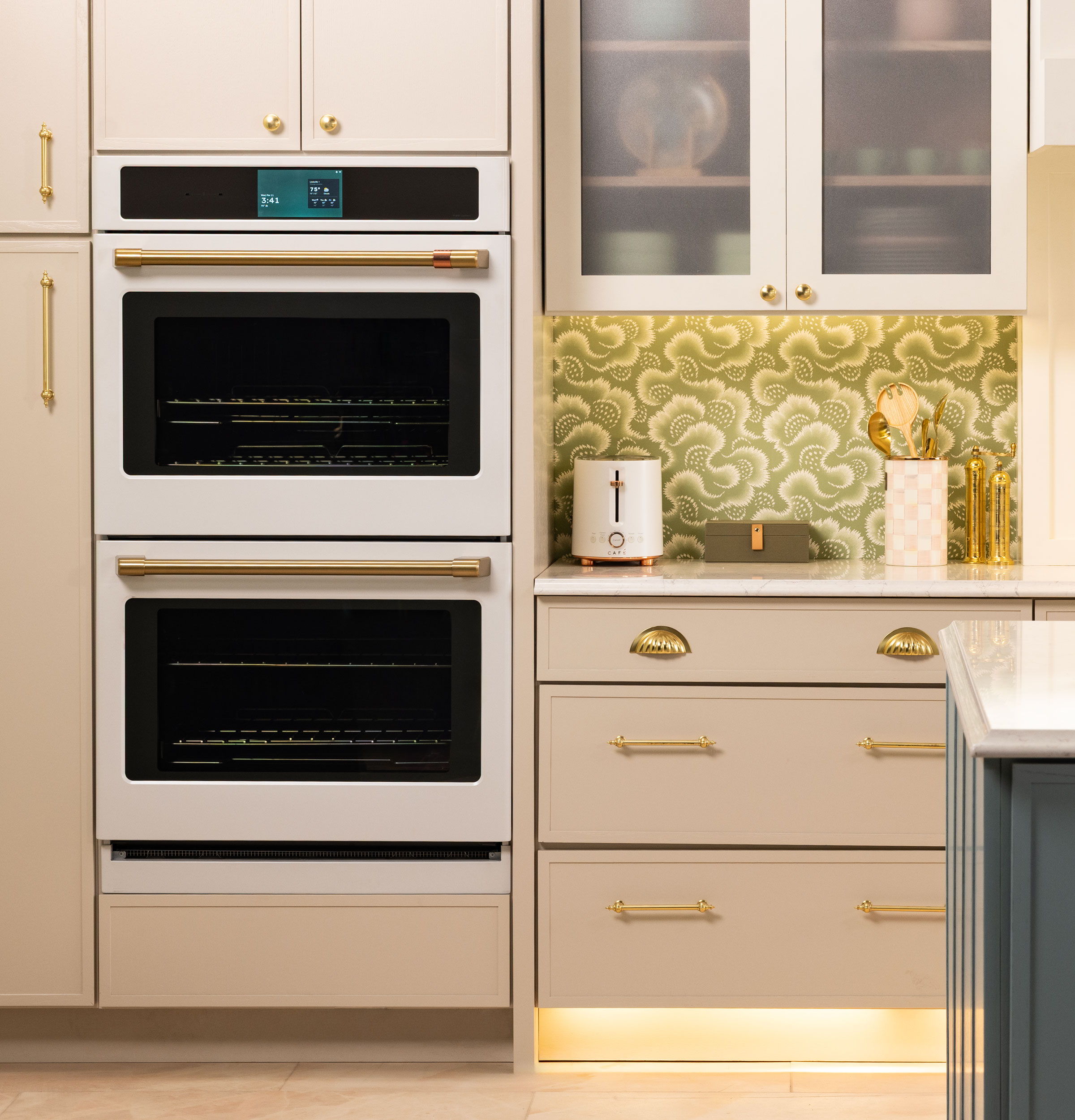 Modern kitchen with double ovens, decorative backsplash, and stylish cabinetry.
