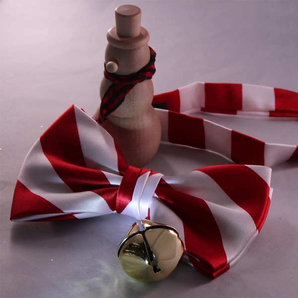 A red and white striped bow tie with a snowman and bell