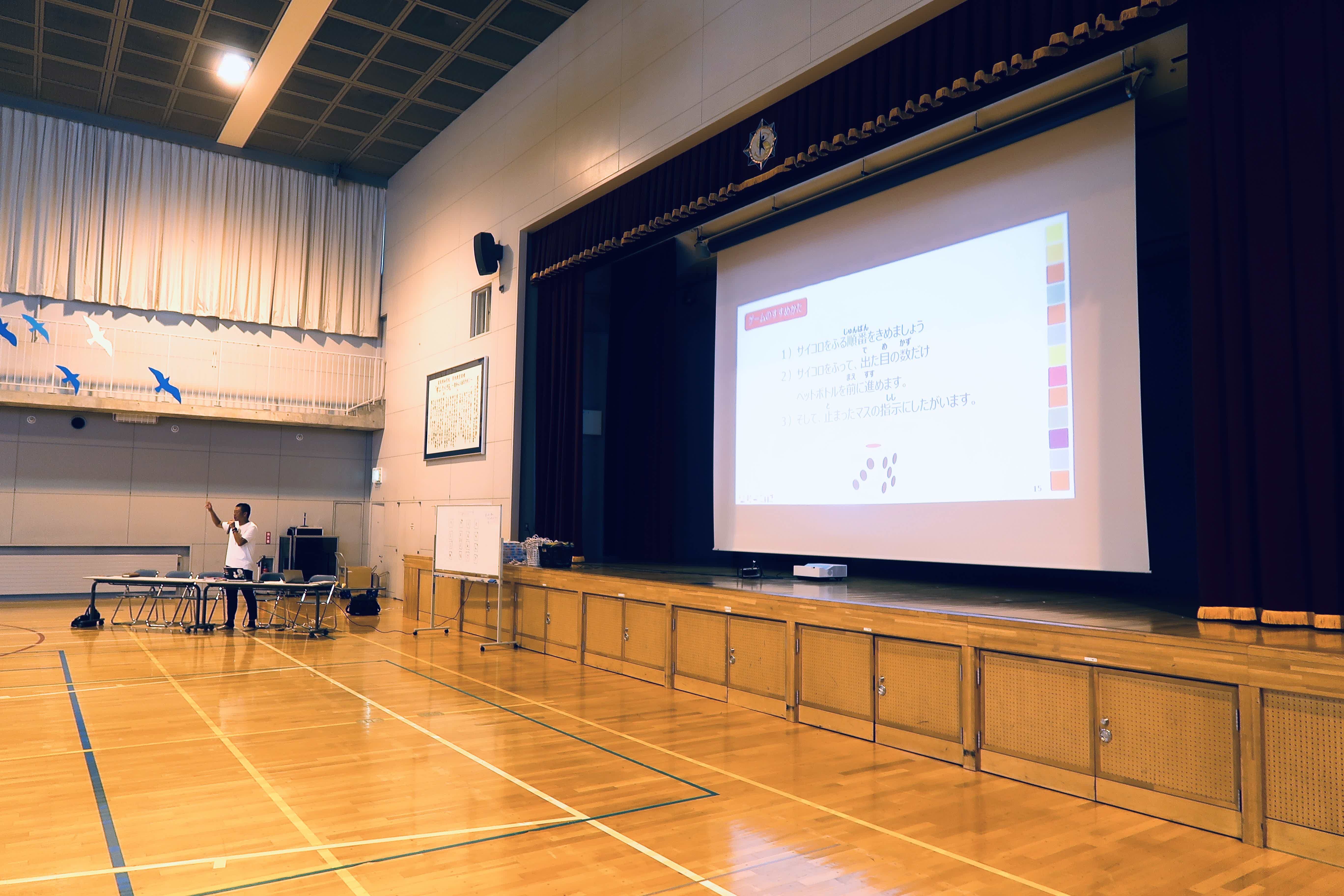 Presentation setup in a spacious auditorium with a large screen.