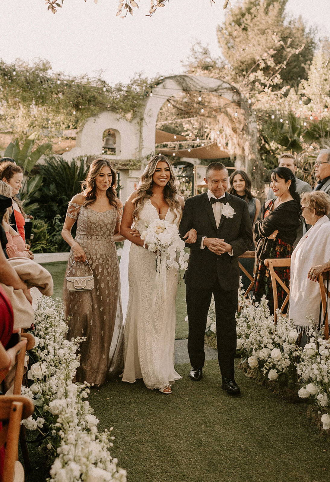 Brides mother and father walking her down the aisle