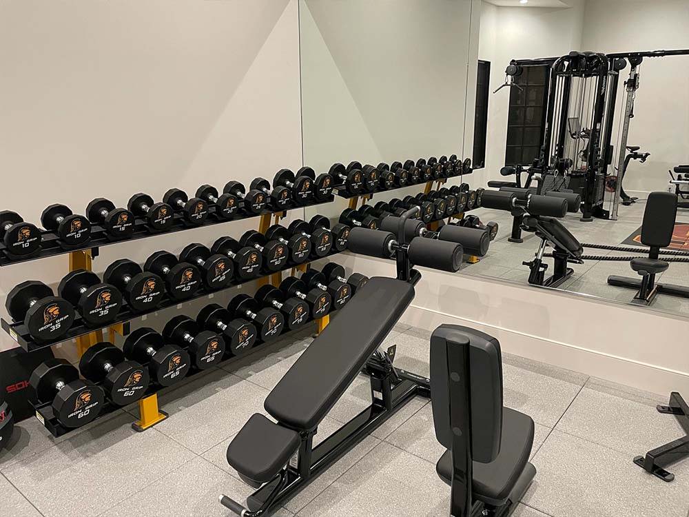 ASU themed home gym with custom dumbbells, decline bench, and more fitness equipment